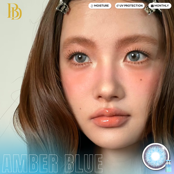 Close-up of a person with amber blue eyes, featuring cosmetic brand branding.