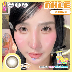 Advertisement for AHLE brown contact lenses with a model wearing them, showing close-up of eyes and product packaging.