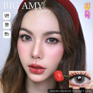 Advertisement for ULENS Premium Contact Lenses with a model wearing contact lenses and a cherry, featuring product details.