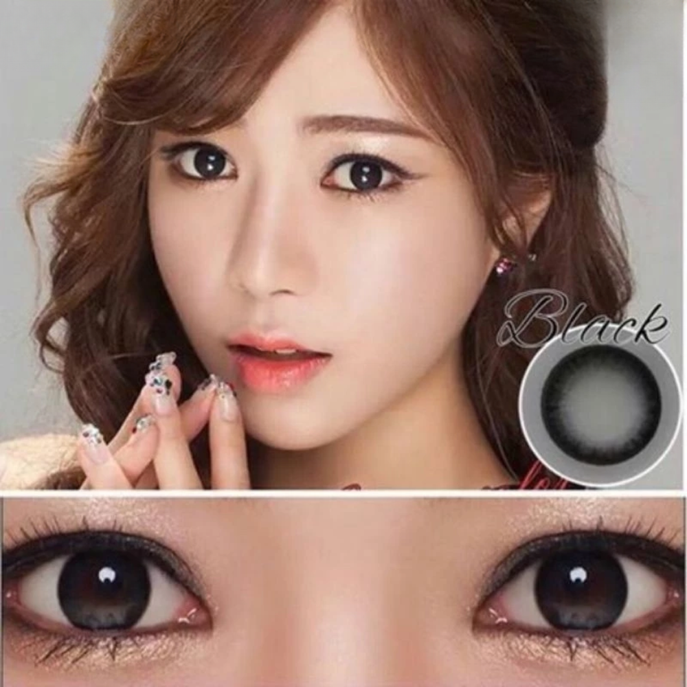 Close-up of a woman's face with brown eyes, wearing black contact lenses.