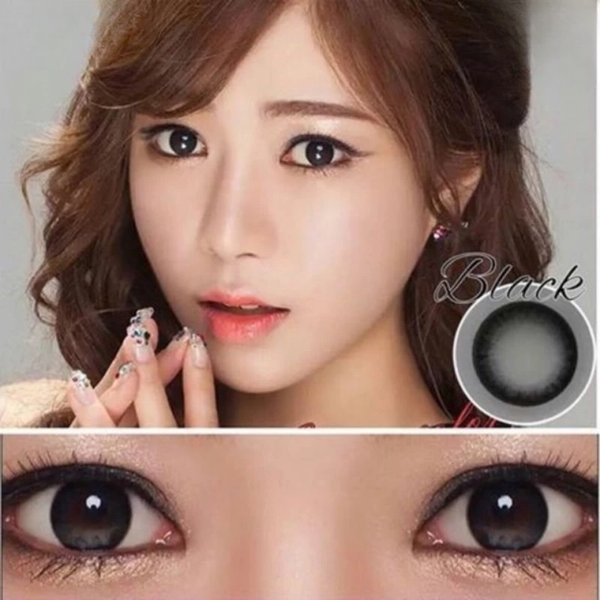 Close-up of a woman's face with brown eyes, wearing black contact lenses.