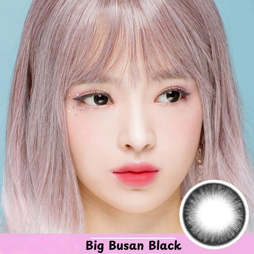Close-up of a woman's face with brown eyes, wearing black contact lenses.