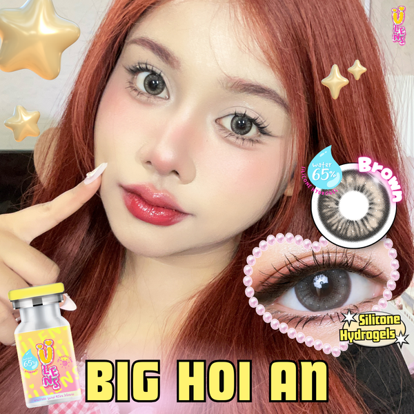 Person with red hair and contact lenses, holding a bottle labeled 'BIG HOI AN'.
