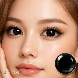 Close-up of a woman's face with a black contact lens displayed next to her eye, featuring the brand 'BUAD'OR'.