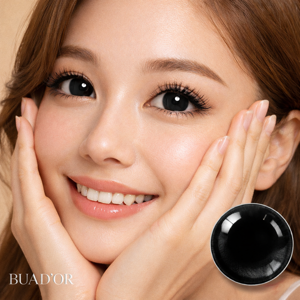 Woman with hands on face, close-up of eye with black sphere, BUAD'OR branding