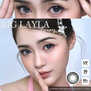 Advertisement for Big Layla gray contact lenses with a close-up of eyes and product details.
