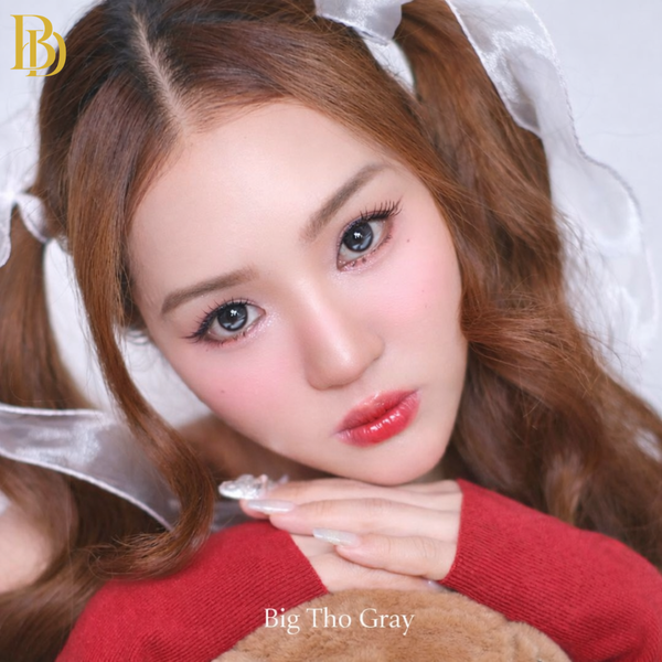 Close-up of a person with long brown hair wearing a red sweater, holding a teddy bear.