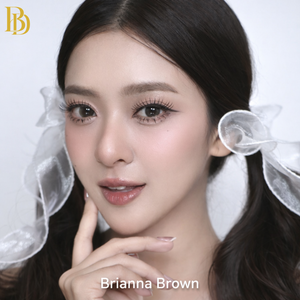 Close-up of a person with decorative hair pieces and 'Brianna Brown' text.