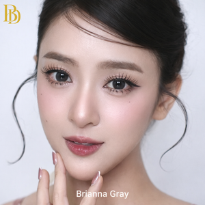 Close-up of a person with styled hair and makeup, featuring the brand 'Brianna Gray'.