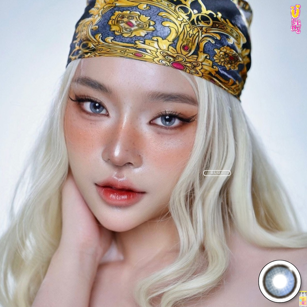 Woman with blonde hair and a colorful headscarf posing against a neutral background