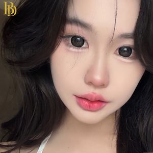 Close-up of a person with dark hair and pink lipstick, with a blurred background with black lenses 