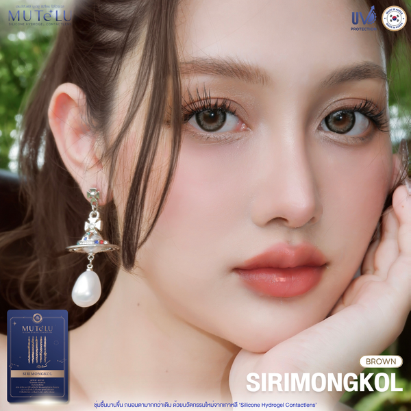 Close-up of a woman wearing earrings with contact lens packaging in the corner.