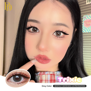 Close-up of a person with dark hair and plaid shirt, featuring eye makeup with Trixie brand logo.